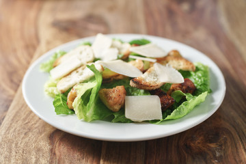 caesar salad with chicken on wood table mediterranean food, shallow focus