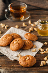 Tea cup with oatmeal cookie on dark wooden table covert tableclo