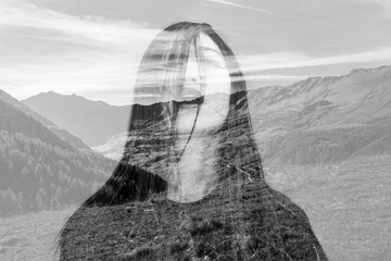 Monochrome double exposure of girl with messy hair and mountains