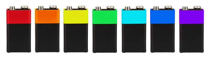 Seven batteries of the type  PP3 in a single row, seven colors of the rainbow (spectrum), on a white background, isolated