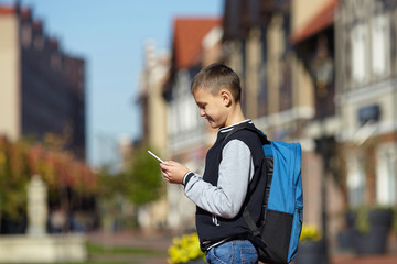young schoolboy using smartphone