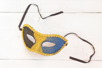 Carnival mask on white wooden background