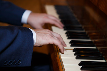 Fototapeta premium Pianist hands playing the Grand piano. Classical music keyboard. Musician in concert performing music on a stringed percussive musical instruments.