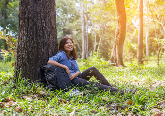 Obraz premium Women hiker with backpack checks map to find directions in wilde