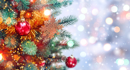 Christmas tree background and Christmas decorations with snow, blurred, sparking, glowing. Happy New Year and Xmas theme