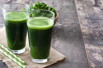Kale smoothie in glass on wooden background.Copyspace
