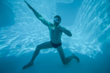 Man posing underwater in swimming pool