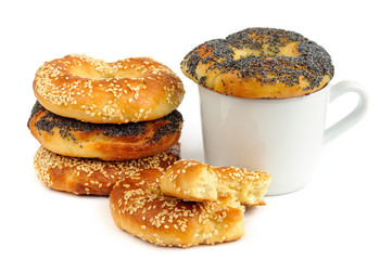 Stack of Poppy and sesame bagels with cup isolated