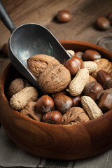 Walnuts, hazelnuts and peanuts in wooden bowl.