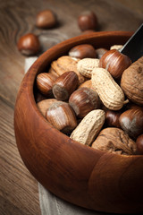 Walnuts, hazelnuts and peanuts in wooden bowl.