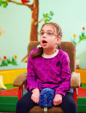 cute girl in wheelchair in kindergarten for children with special needs
