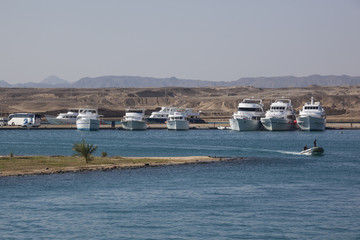Fototapeta na wymiar Anchored yachts against desert landscape