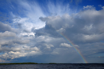 Colorfull rainbow under beaufitul cloud over lake
