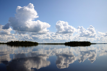 Blue sky and small clouds above the mirrored big lake