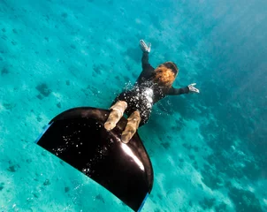 Foto op Canvas Beautiful freediver girl swims above sea bottom © serg269