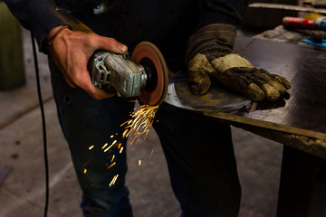 The blacksmith manually forging the molten metal on the anvil