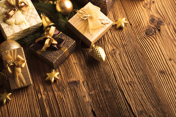 Golden Christmas decoration. Presents in boxes on a wooden background with copy space. Golden baubles. Christmas theme. Golden and brownish aesthetics. Christmas spices.