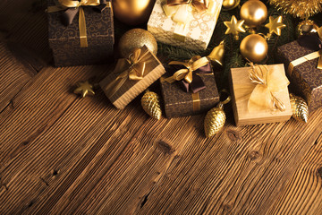 Golden Christmas decoration. Presents in boxes on a wooden background with copy space. Golden baubles. Christmas theme. Golden and brownish aesthetics. Christmas spices.