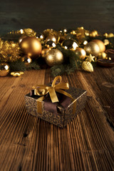 Golden Christmas decoration. Presents in boxes on a wooden background with copy space. Golden baubles. Christmas theme. Golden and brownish aesthetics. Christmas spices.