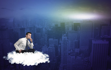 Fototapeta premium Man sitting on a cloud above the city