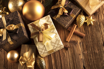 Christmas theme. Presents on a wooden table. Golden and brownish aesthetics.