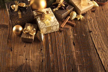 Christmas theme. Presents on a wooden table. Golden and brownish aesthetics.