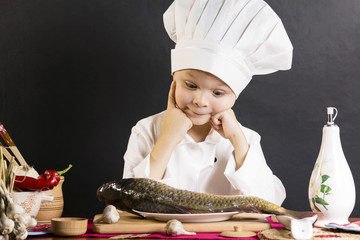 funny boy chef prepares fish