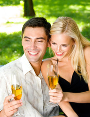 couple celebrating with champagne together, outdoors