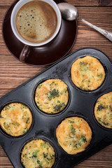 Breakfast egg muffins with broccoli and cheese. Cup of coffee.