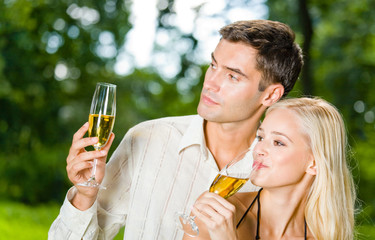 happy couple celebrating with champagne outdoors