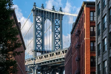 Rolgordijnen De Manhattan Bridge en een straat in Brooklyn, omzoomd door oude gebouwen van rode baksteen © kmiragaya