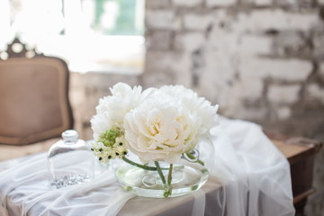 Vase with beautiful David Austin roses on a table. Nice rare white flowers for rustic wedding decoration. Loft style. Fresh bouquet for bride. Blurred background.