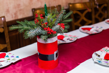 Christmas table place setting with christmas pine branches,ribbon and bow. Xmas and New Year holidays background
