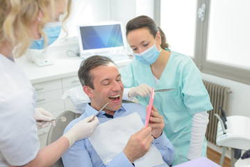 male patient and dentist with assistant during check up