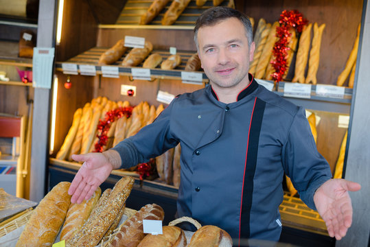 bakery shopkeeper is proud of his bread production