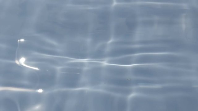 Surface of waving liquid in blue container with nice visual effect 4K 2160p 30fps UltraHD footage - Pool like water space with light reflections of sun 3840X2160 UHD video