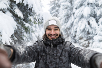Fototapeta na wymiar Young Man Smile Camera Taking Selfie Photo In Winter Snow Forest Guy Outdoors Walking White Park