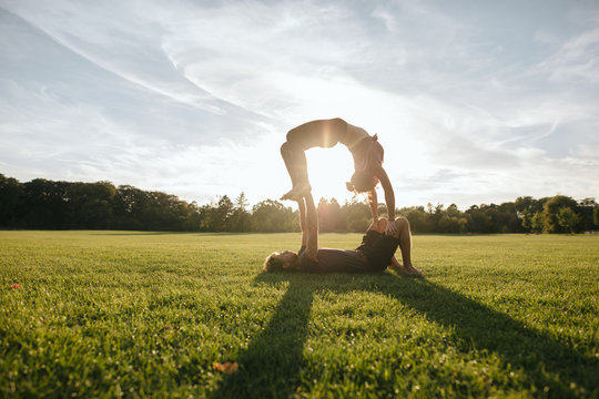 Couple doing acrobatic yoga exercise at park