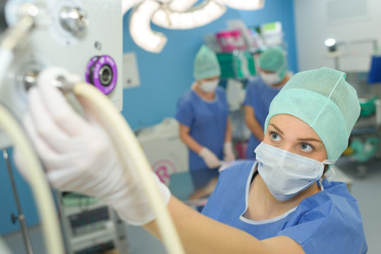 female surgeon setting up medical machine