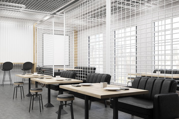 Side view of a cafe interior with grate and black sofas