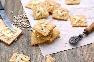 Homemade gluten free crackers with sunflower seeds and cheese on wooden background