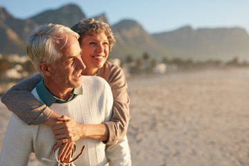 Senior couple enjoying their vacation at the beach - obrazy, fototapety, plakaty