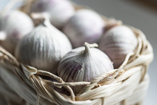 Aromatic fresh garlic bulbs in little basket for sale
