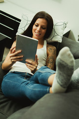 Brunette girl with a tablet at home