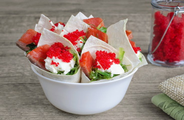 Sandwiches with seafood in envelopes of tortillas. Wooden background, selective focus.