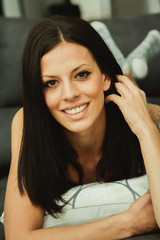 Fototapeta premium Cool brunette girl sitting on the sofa