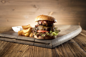 Fresh home-made hamburger served on wood, place for typography