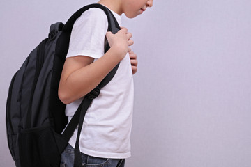 School child with backpack. Incorrect posture concept.