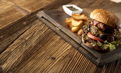 Fresh home-made hamburger served on wood, place for typography