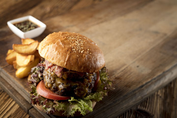 Fresh home-made hamburger served on wood, place for typography